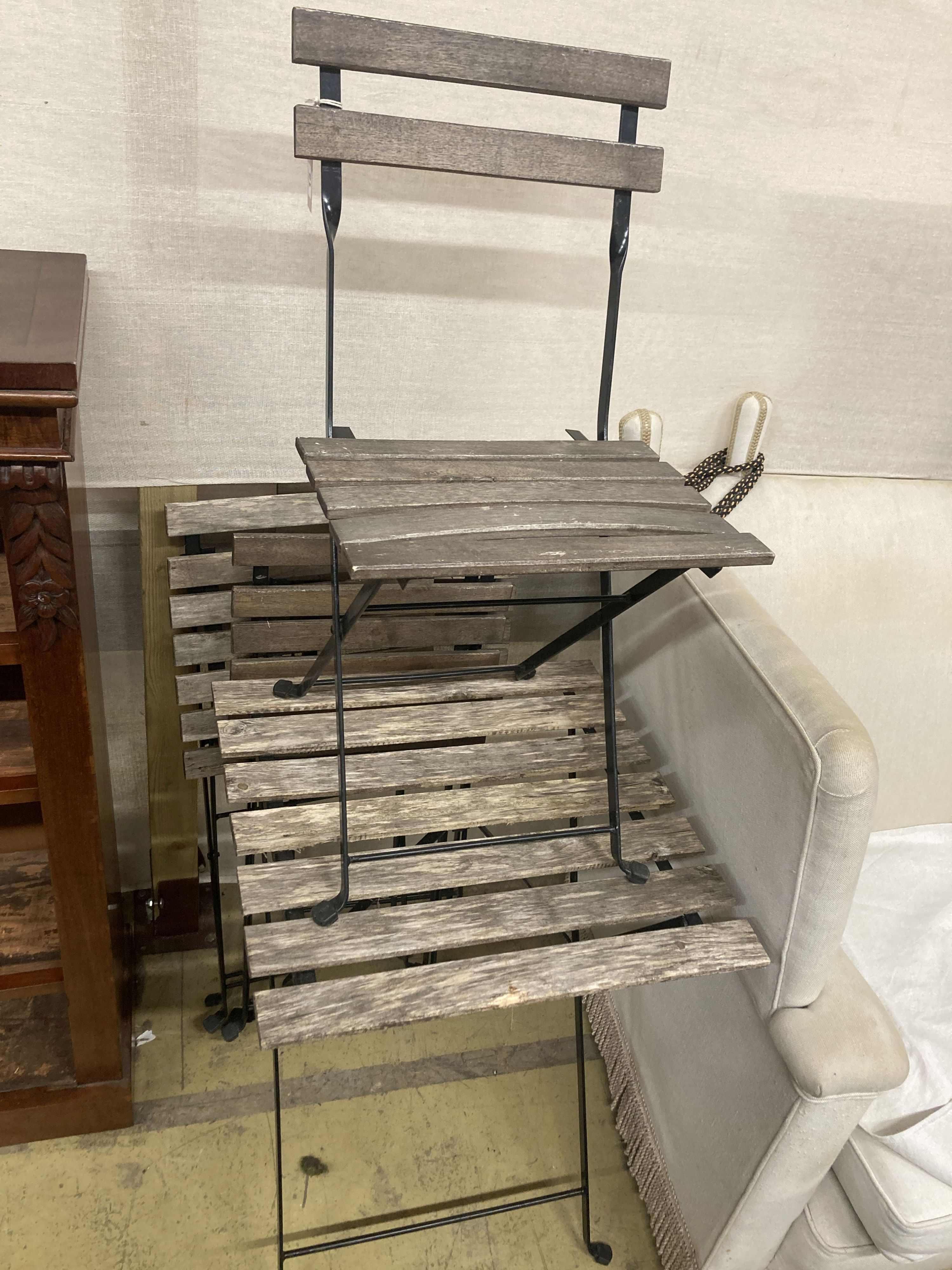 A slatted wrought iron folding garden table, width 54cm, depth 55cm, height 72cm and four chairs